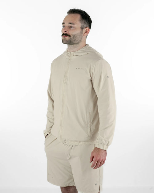 Man wearing a beige jacket and shorts on a white background