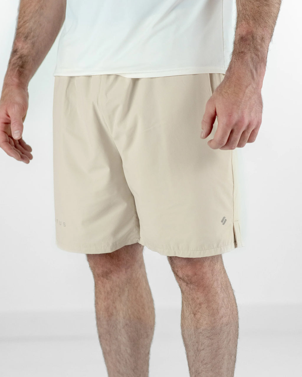 Beige shorts worn by a person on a white background