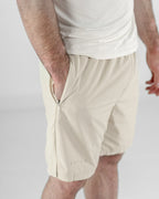 Beige shorts with a zipper on a plain background