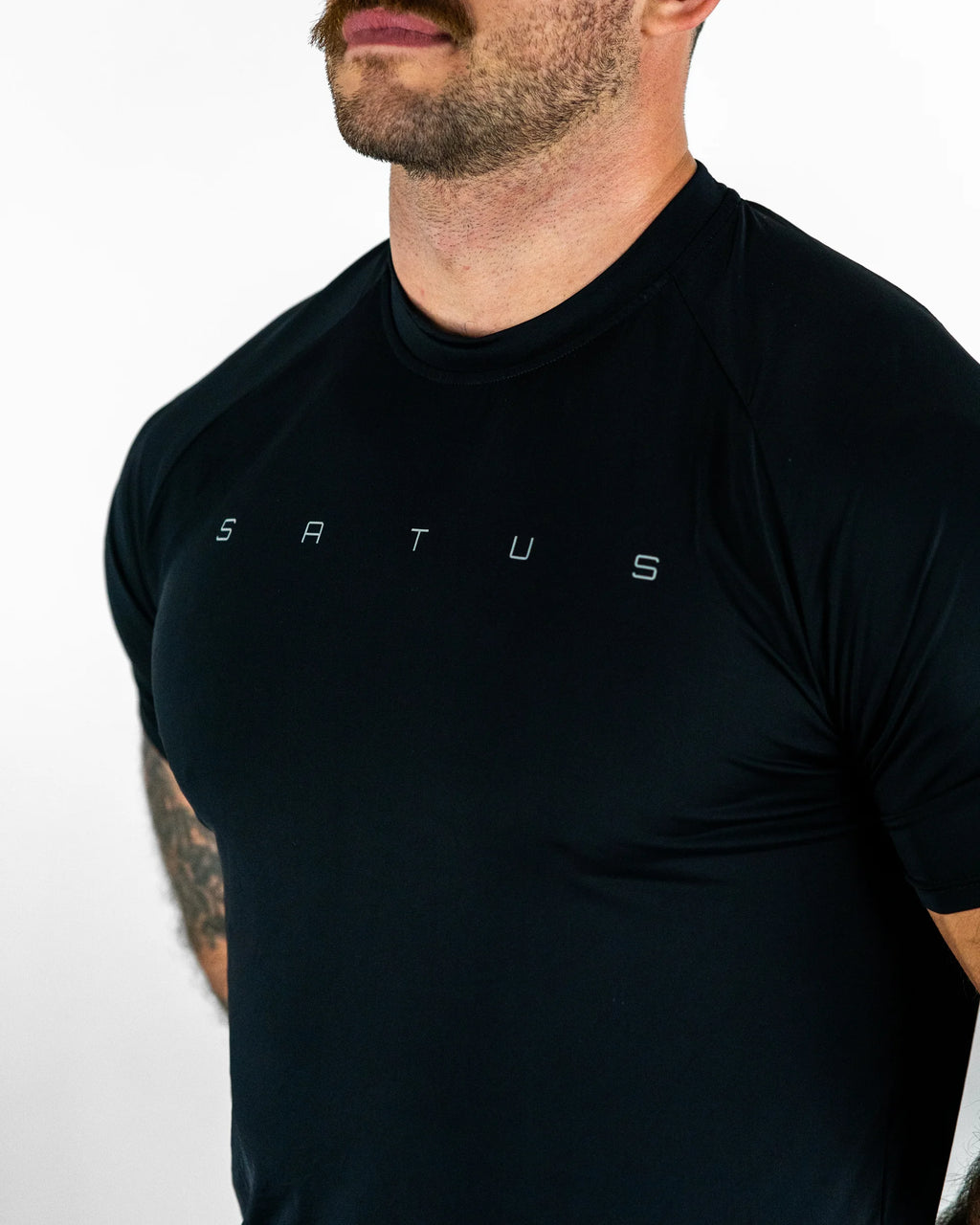 Man wearing a black athletic shirt with 'Satus' branding on a white background