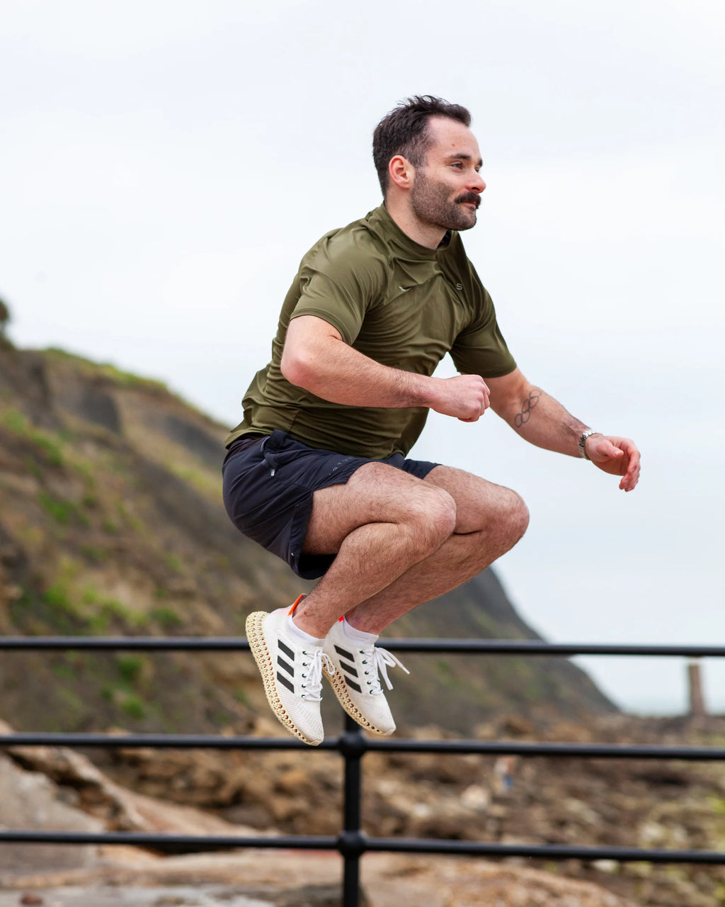 Man in athletic wear jumping outdoors with a scenic background