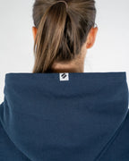 Person wearing a blue hoodie with a brand logo on the hood against a white background