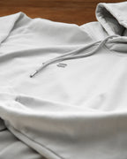 Gray hoodie with drawstring on a wooden surface