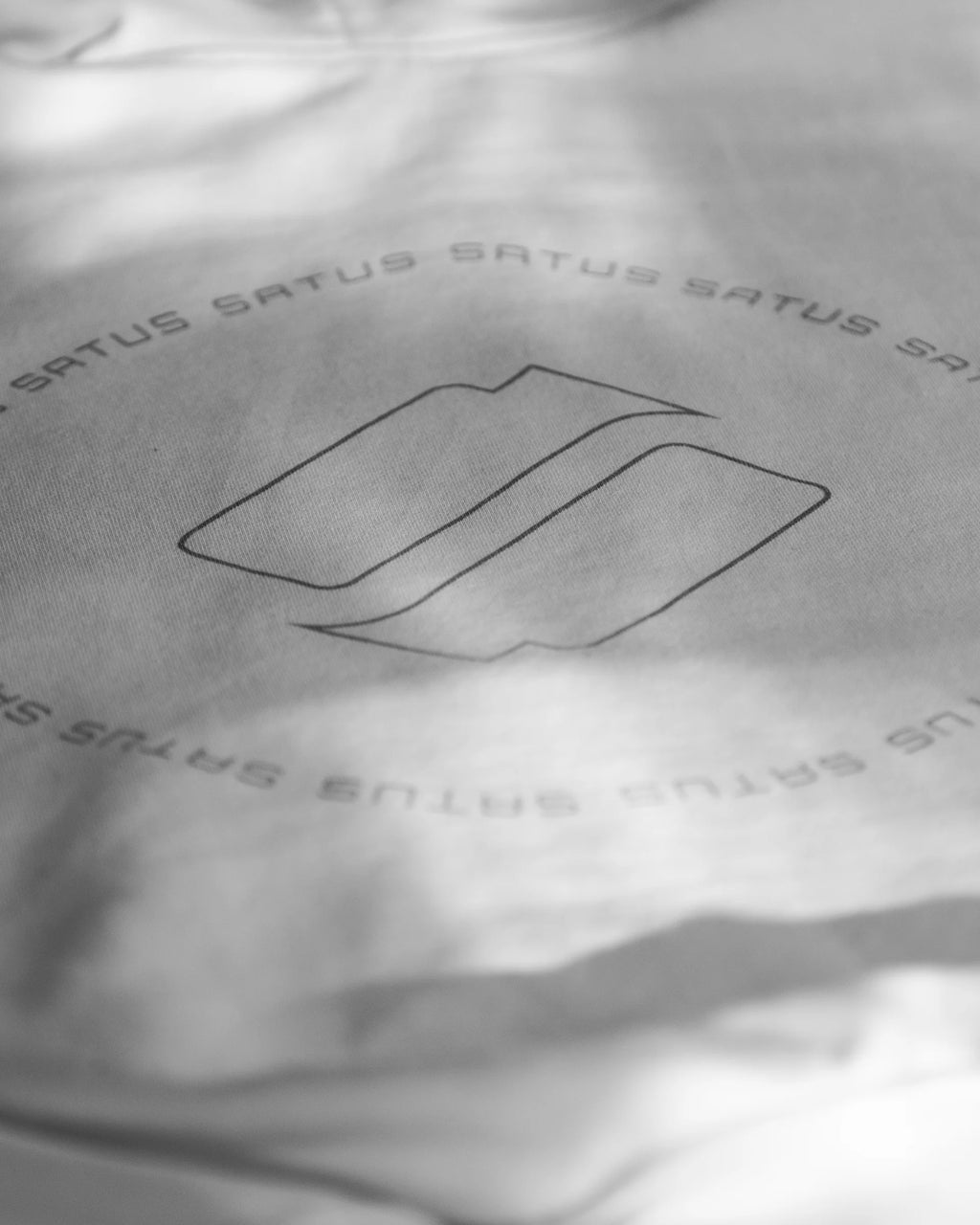 Close-up of a cotton hoodie with 'Satus' branding and logo.