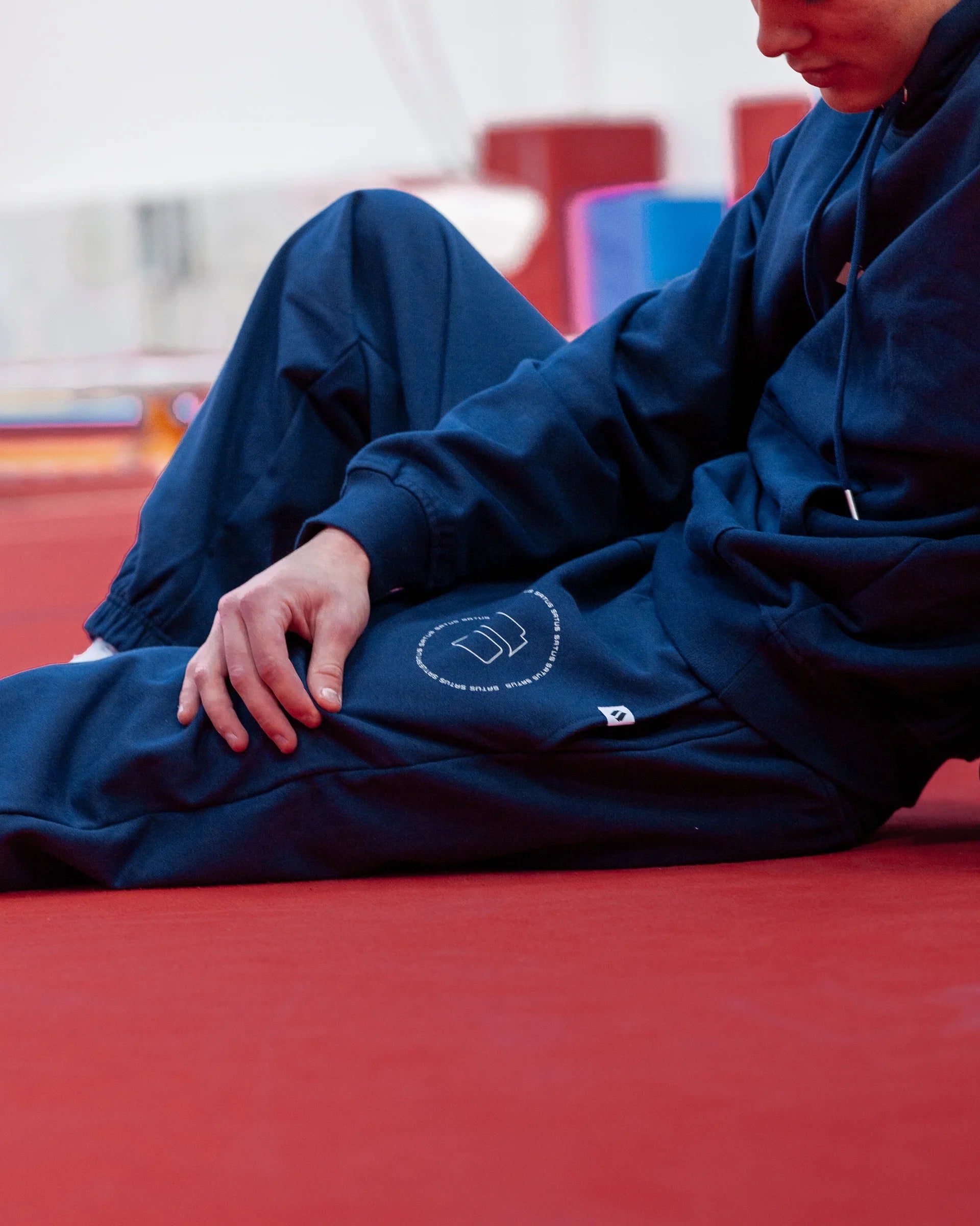 Person wearing navy blue joggers in a gym.