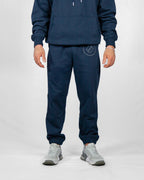 Person wearing a navy tracksuit with a logo on a white background