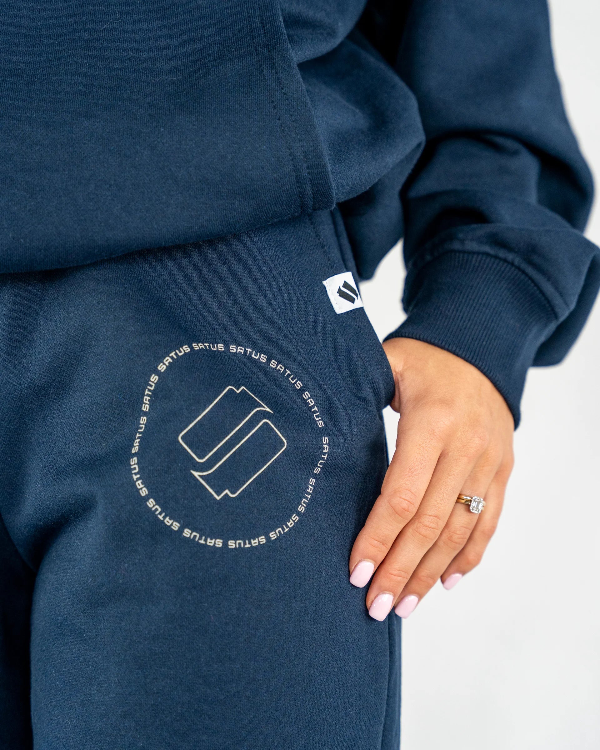 Navy blue joggers closeup with a logo and text on a white background