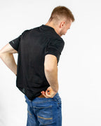 Man wearing a black t-shirt and blue jeans on a white background